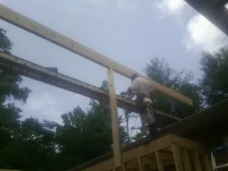 Carpenter setting a ridge beam over a new addition frame — Ice Dam Removal by Roofing Brothers in Weehawken