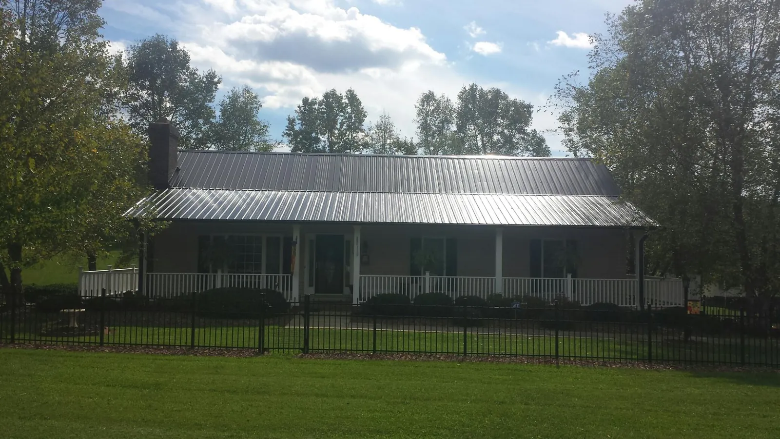 Gray metal roof on a brick ranch with a full width front porch — Gutter Guard Installation work by our crew in Weehawken