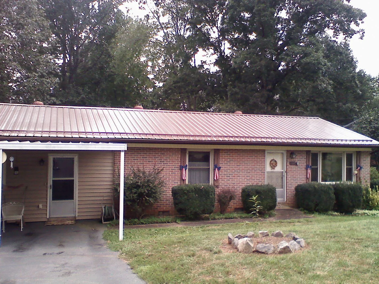 Bronze metal roof and carport on a brick ranch home — Roof Repair work by our crew in Weehawken